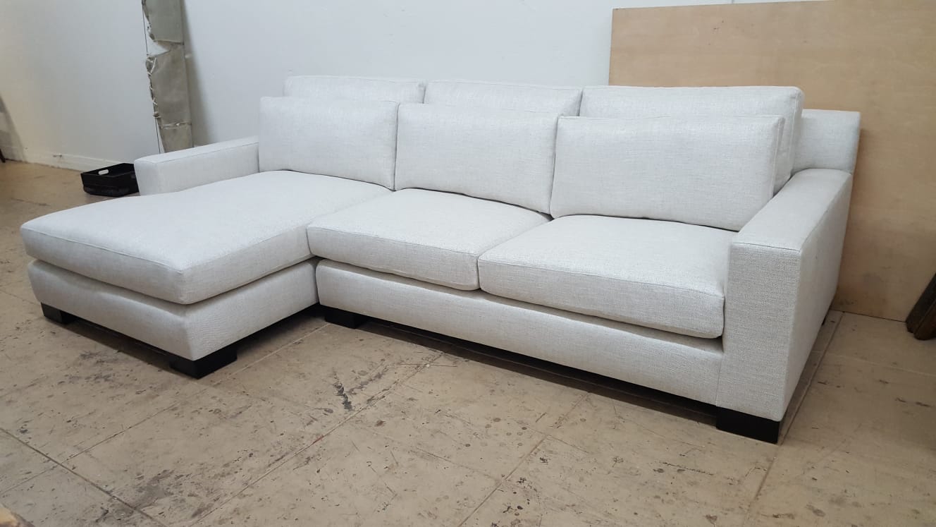 Custom Upholstery - White sectional sofa with black coffee table