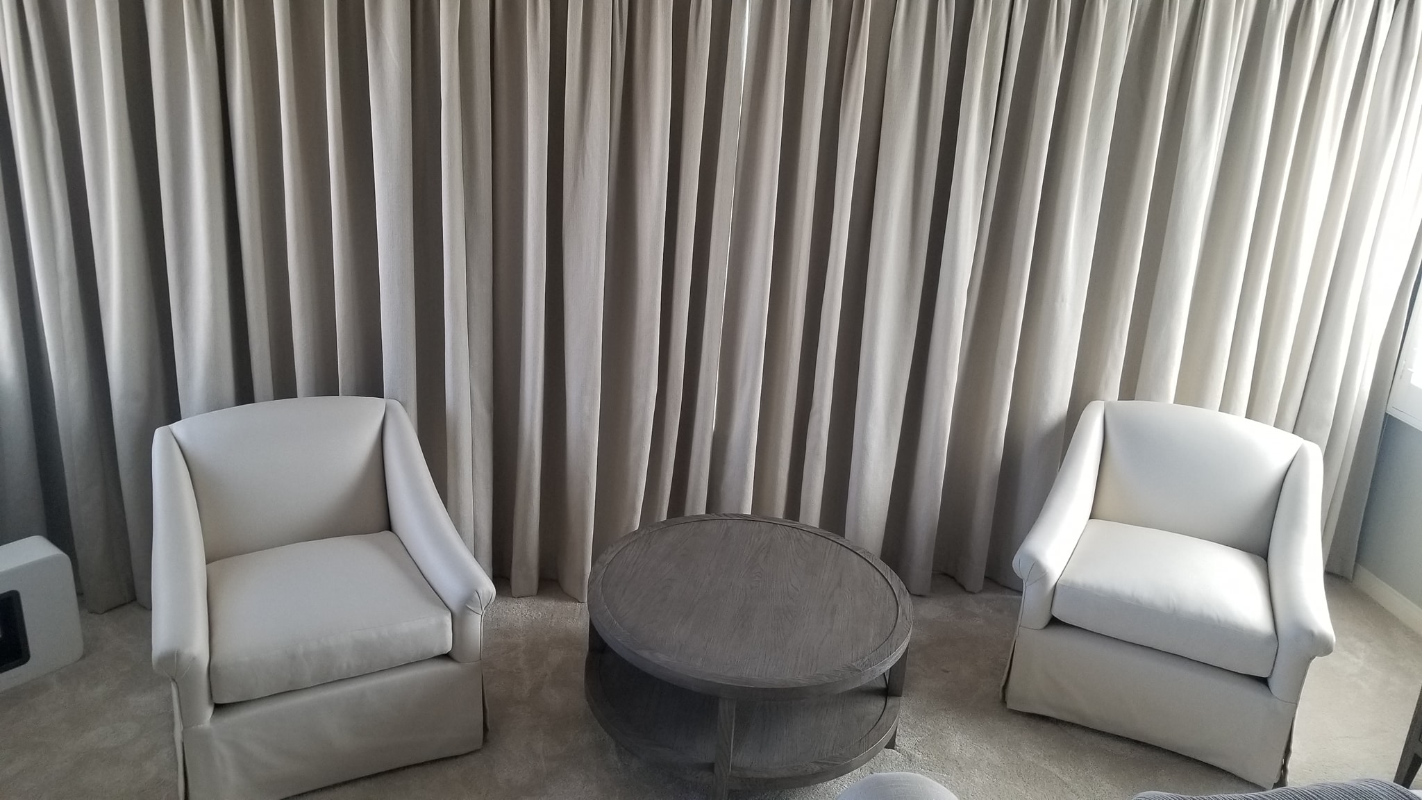 Custom Drapes - Gray floor-to-ceiling curtains behind two upholstered white armchairs